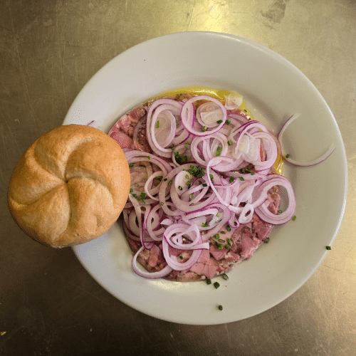 Bauernpresswurst mit Zwiebeln in Essig und Öl.