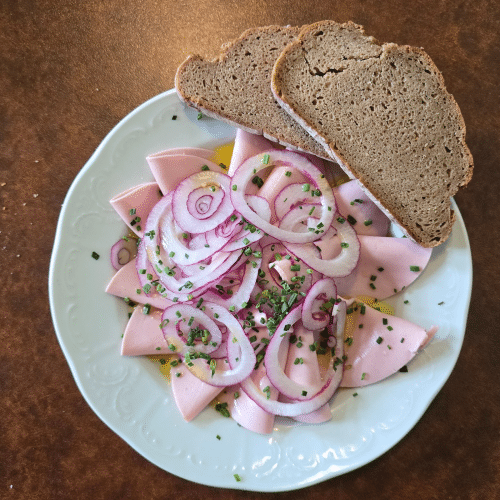 Extrawurst mit Zwiebeln in Essig und Öl.