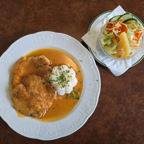 Naturschnitzel im Saft mit Reis und Salat.