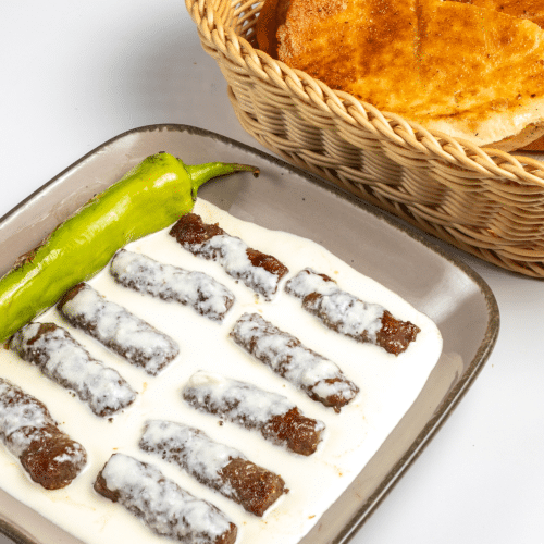 Cevapcici (10 Stück) in Kajmak