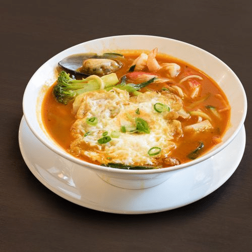 Hausgemachte Nudelsuppe mit Thai-Rot-Currysauce und Meeresfrüchten (scharf)